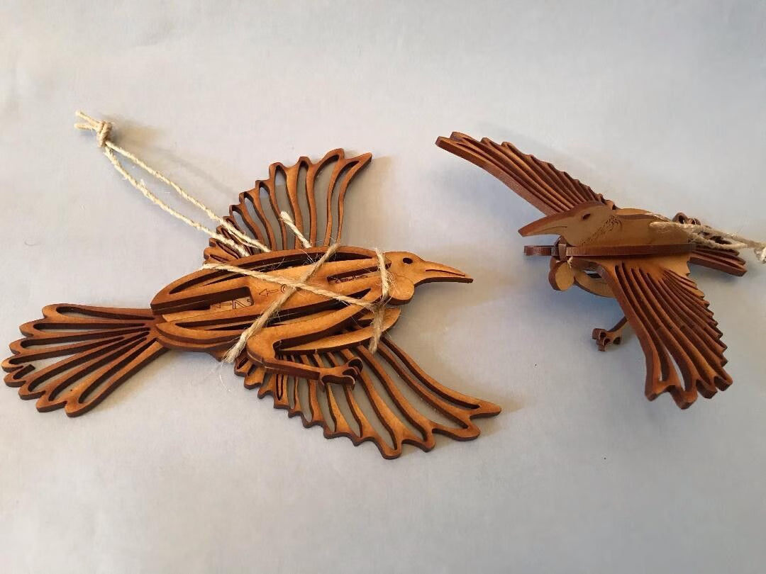 Two wooden bird ornaments on a light gray background