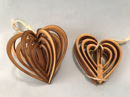 Two heart-shaped leather decorations on a light gray background
