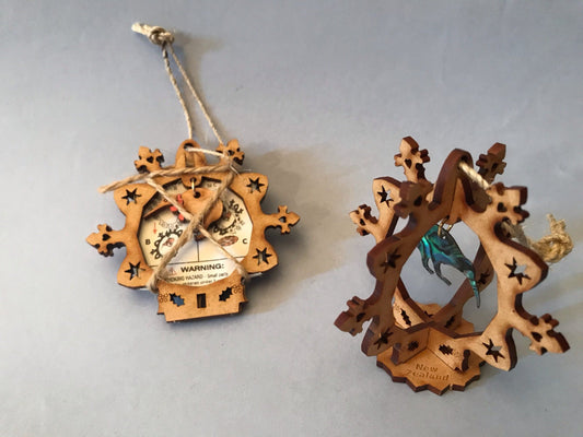 Two 3D wooden snowflake Kiwi decoration items on a plain background