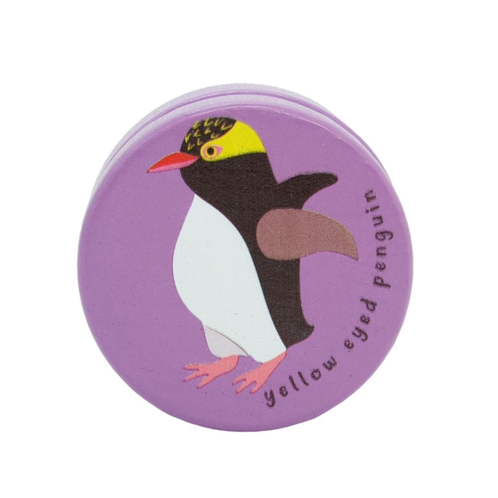 Round purple yoyo with a yellow-eyed penguin illustration on a white background