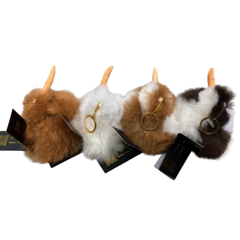 Four fluffy kiwi key rings made with Alpaca hair on a white background