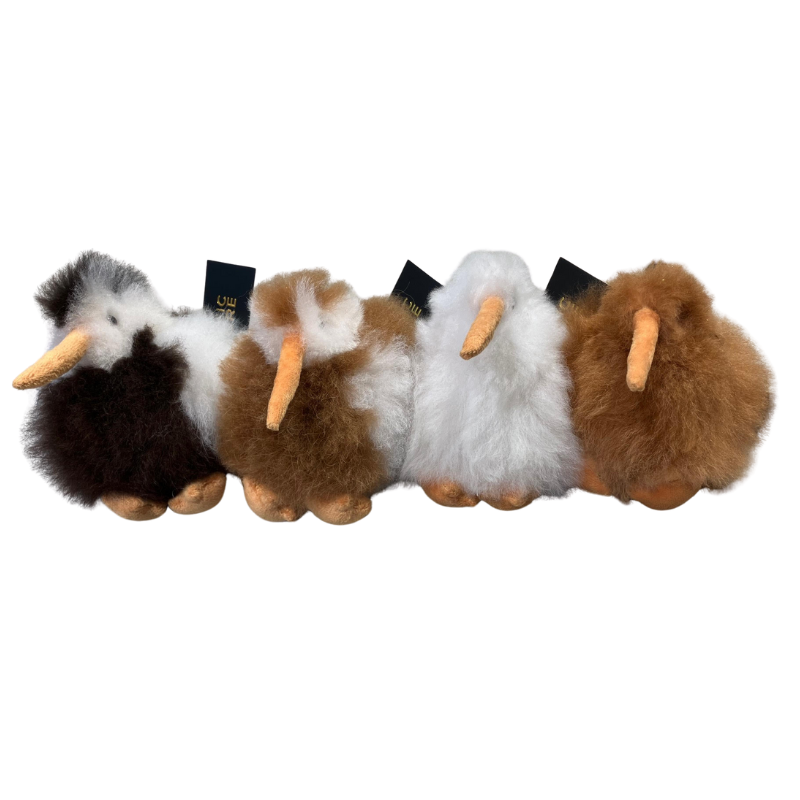 Four fluffy kiwi key rings made with Alpaca hair on a white background