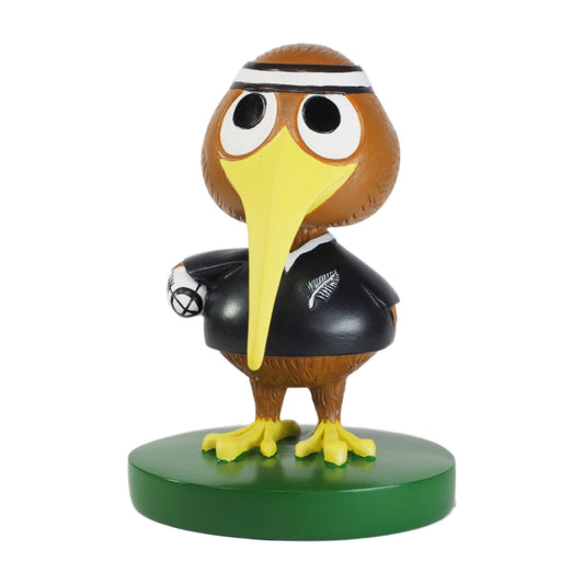 Figurine of a kiwibird character with a yellow beak and black outfit on a green base