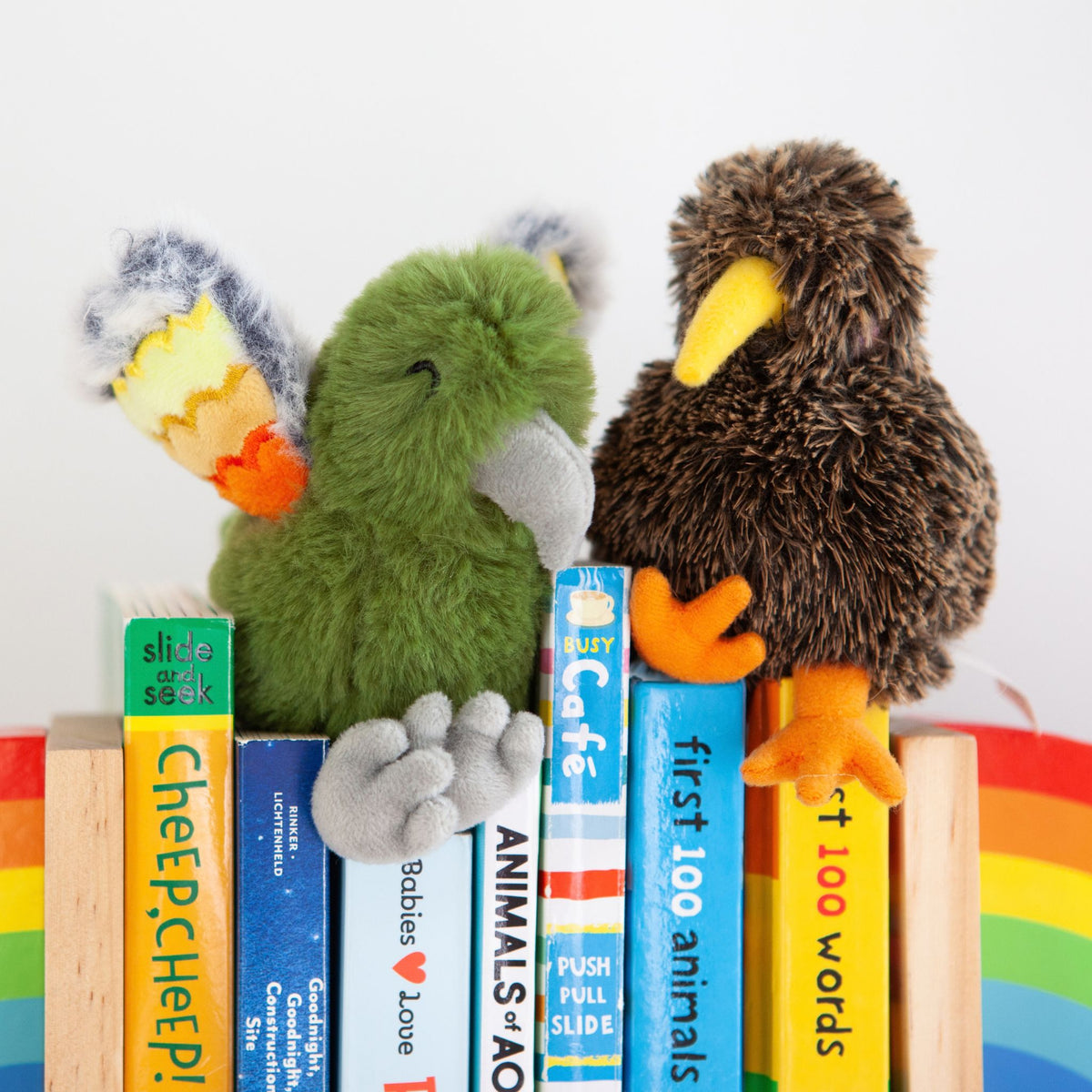 kea and kiwi soft toys on books