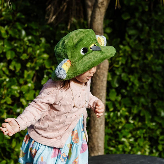 Child wearing a green kea hat outdoors