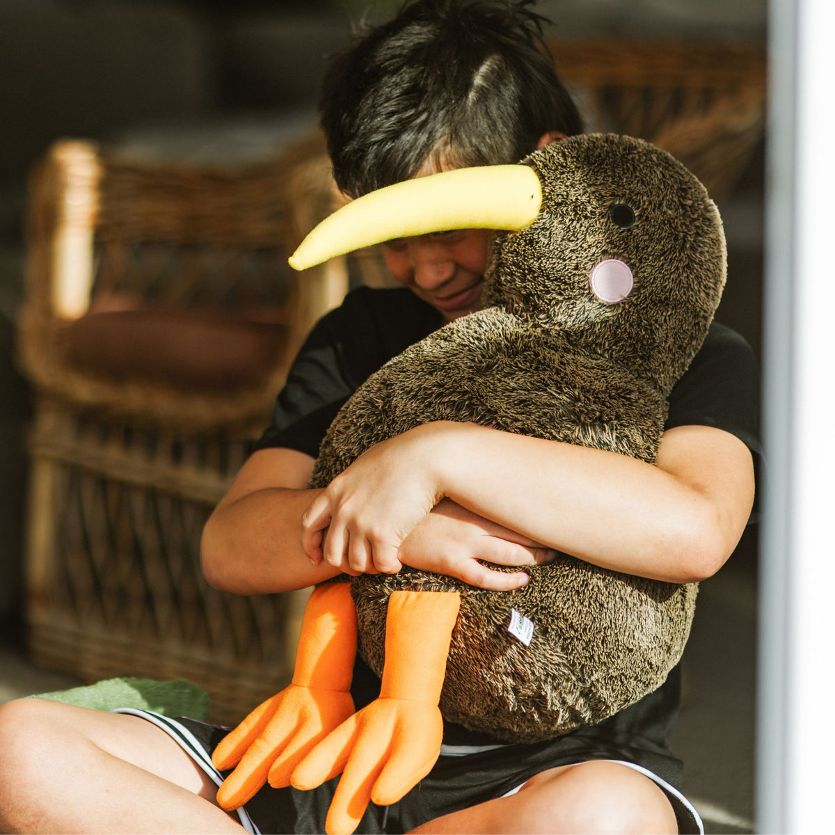 A boy holding Kiwi soft toy large