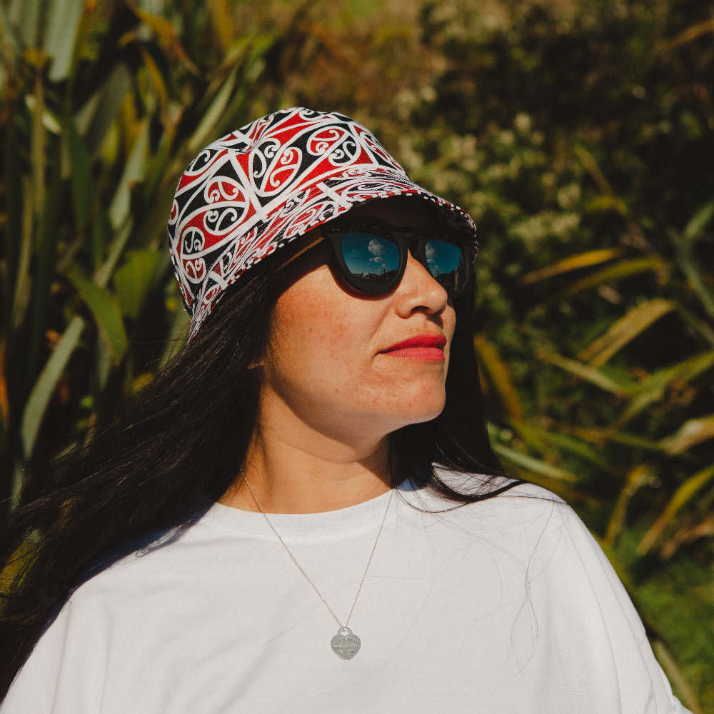 Woman wearing a patterned headscarf and sunglasses with a green, natural background