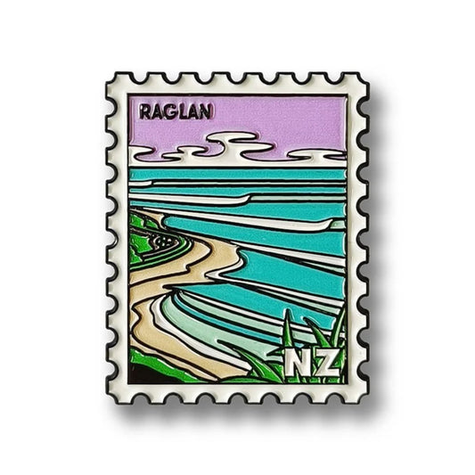 Enamel magnet with a design of a coastal scene and 'Raglan' text on a white background