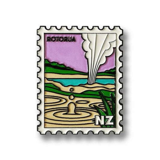 Enamel magnet with a design of Rotorua, New Zealand, featuring a lake and geothermal activity.