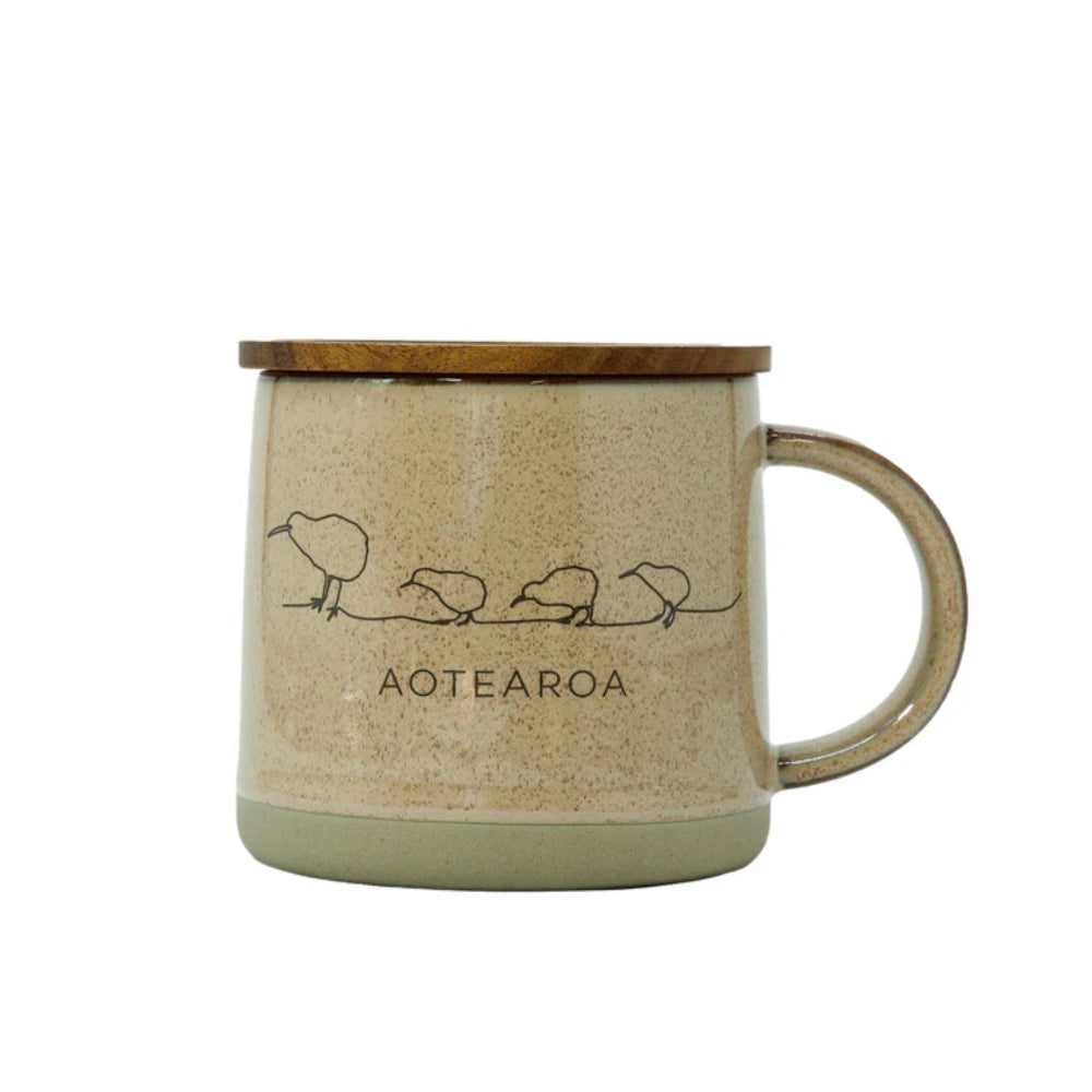Beige mug with wooden lid and handle, featuring illustrations of kiwis and the word 'Aotearoa'.