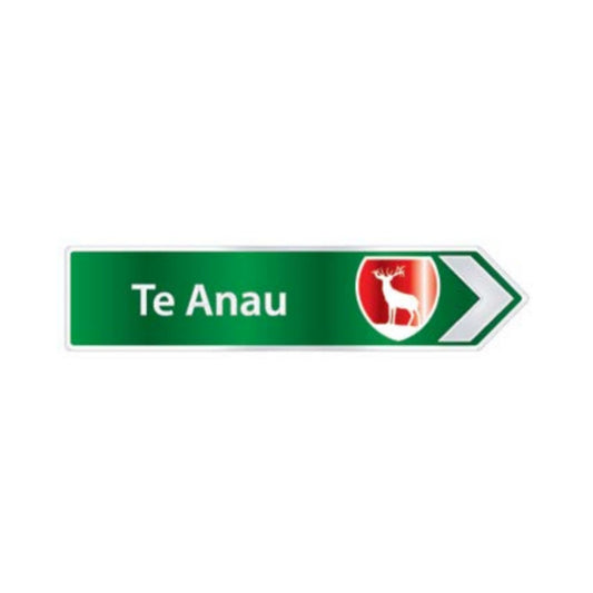 Green directional sign with 'Te Anau' text and deer logo on a white background