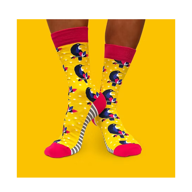Colorful socks with a tui birds pattern on a yellow background