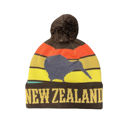 A multicolored beanie with a kiwi bird design and the text 'NEW ZEALAND' on a brown background with red and yellow stripes.