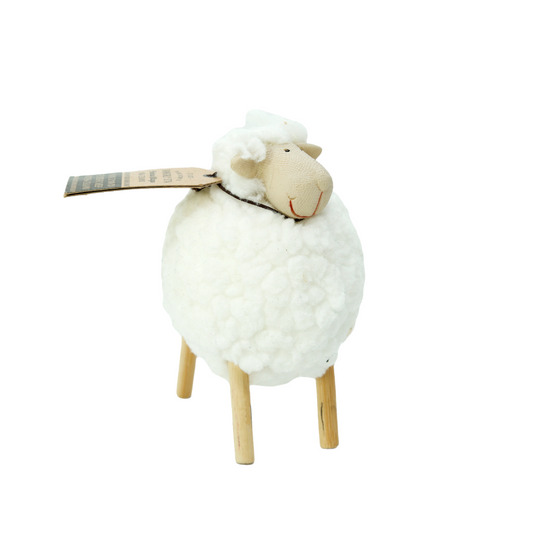 Decorative sheep figure with a white fleece and wooden legs on a white background