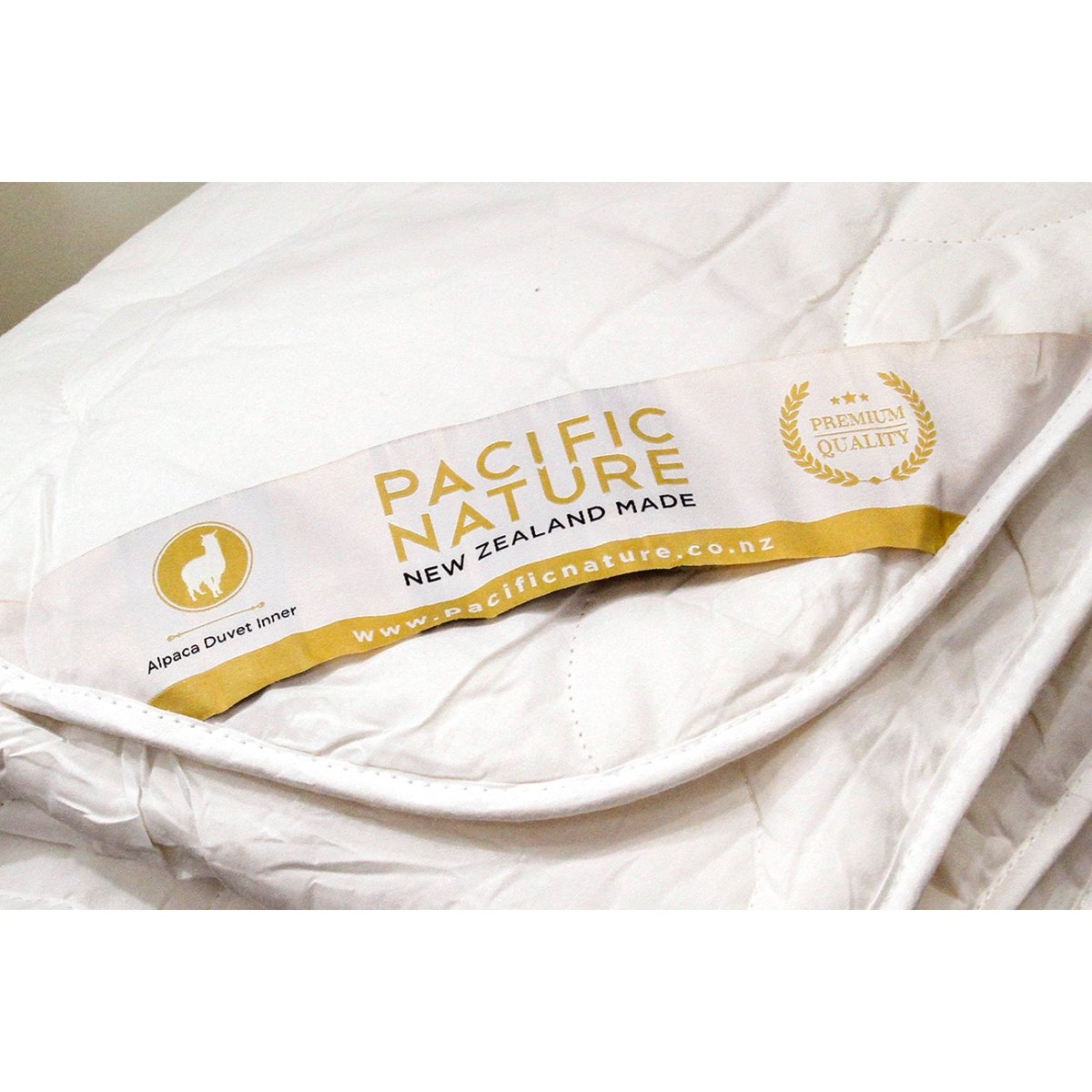 A beige Pacific Nature alpaca duvet cover displaying the brand's logo and information.