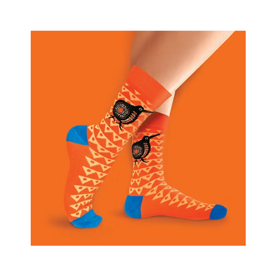 Orange socks with black bird design worn by a person on an orange background