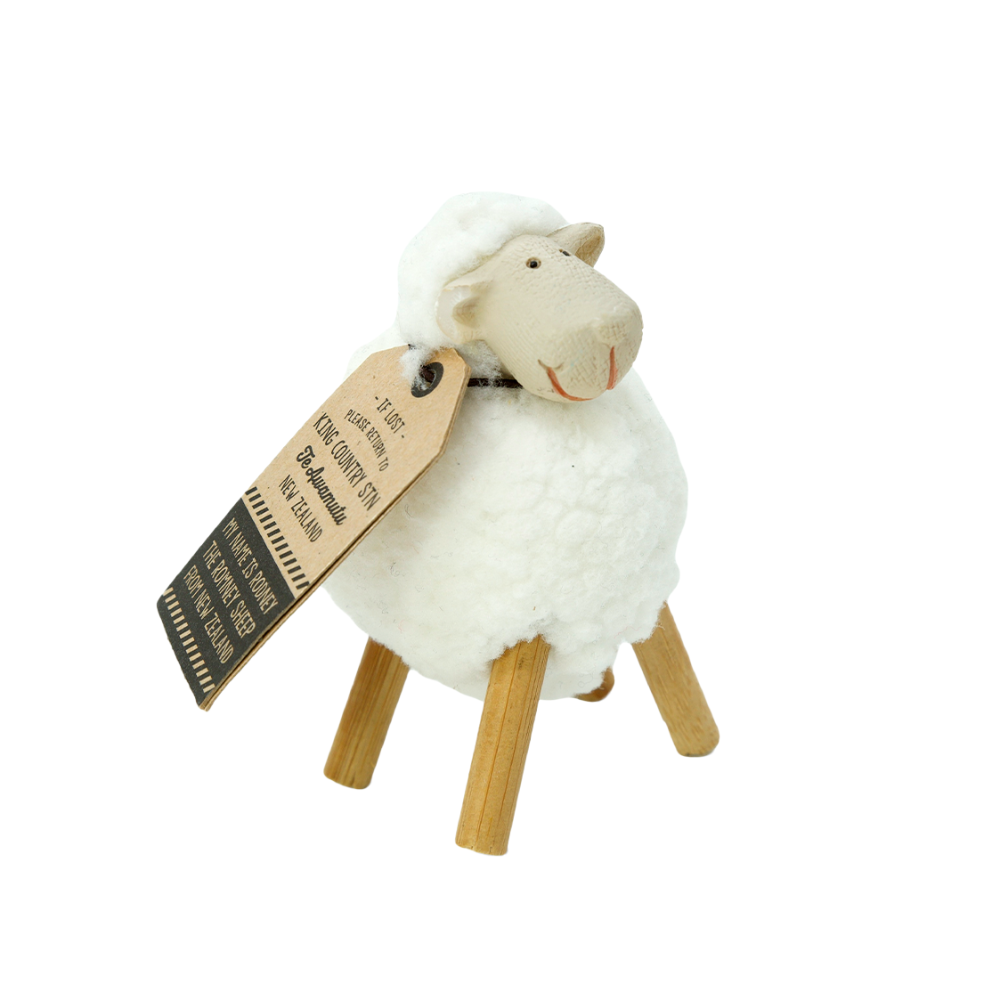 Small white woolly sheep Rodney figurine with a tag on a white background
