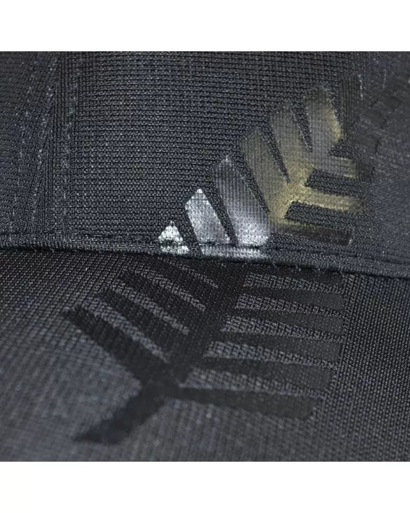 Close-up of a black cap with logo details.
