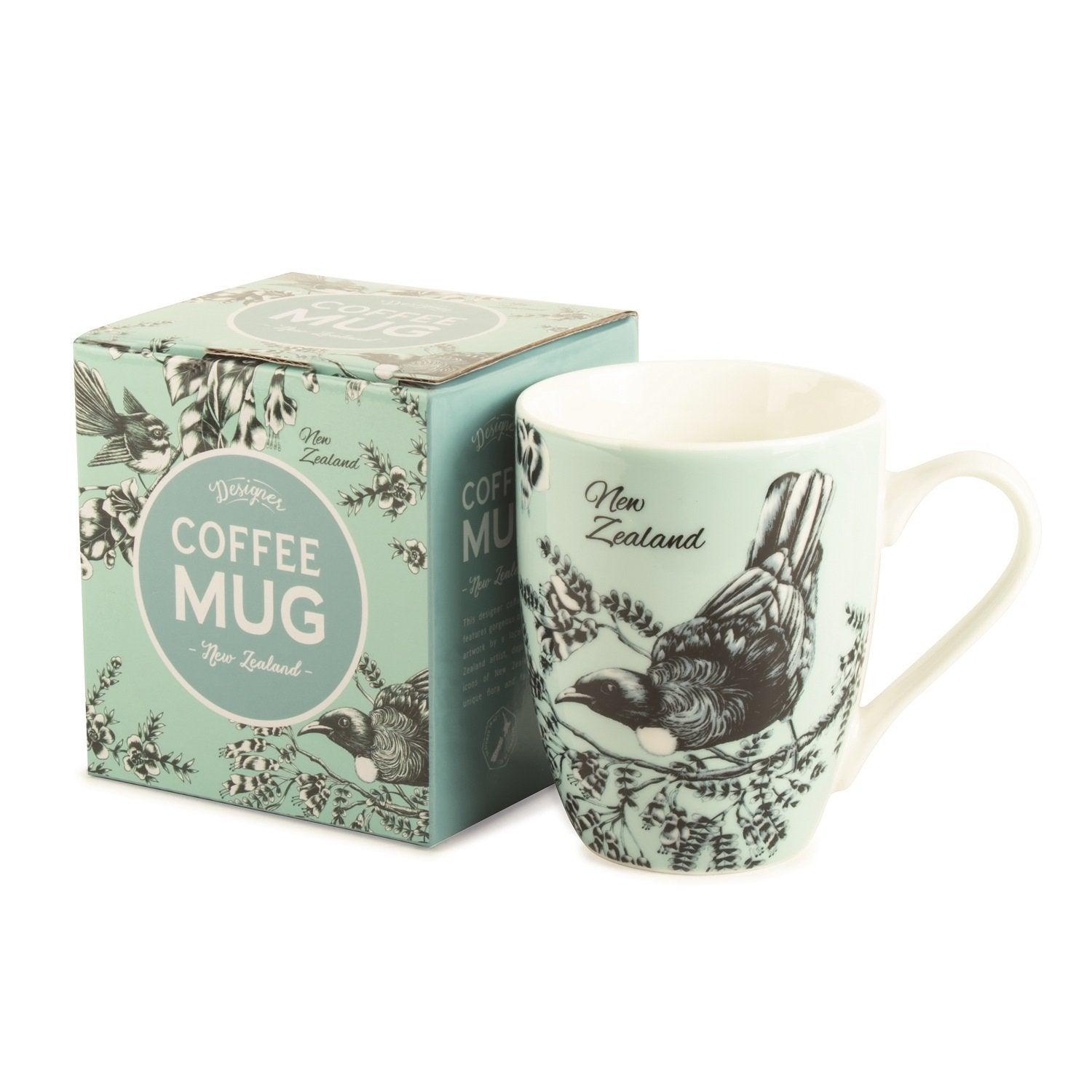 Light blue coffee mug with a bird on it and box next to it.